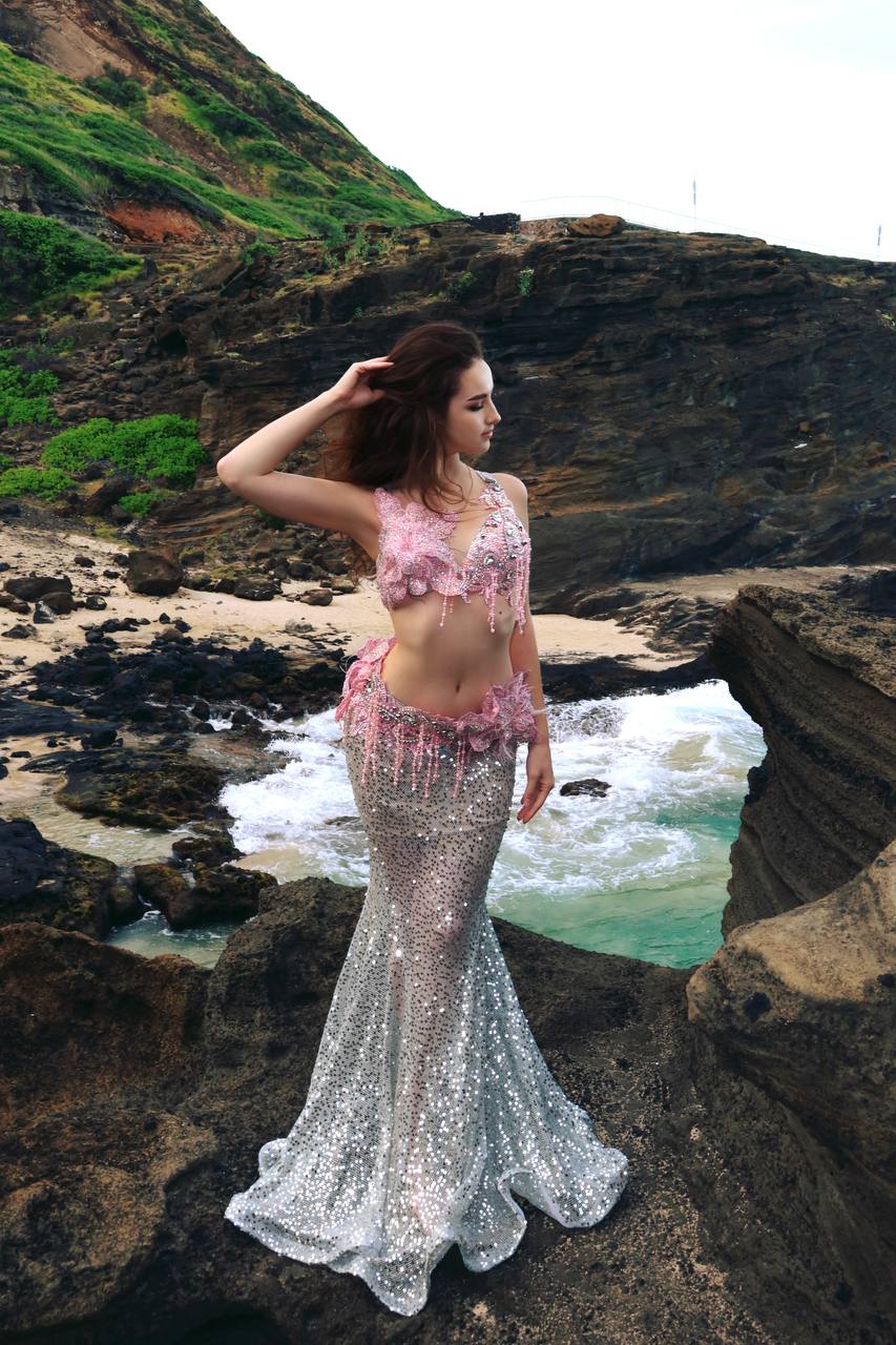 Angelina with a hand in her hair posing on the shoreline